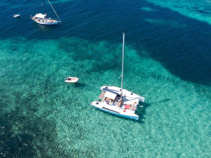 boat aventura 28 anchored in espalmador island with a light blue water of the sea